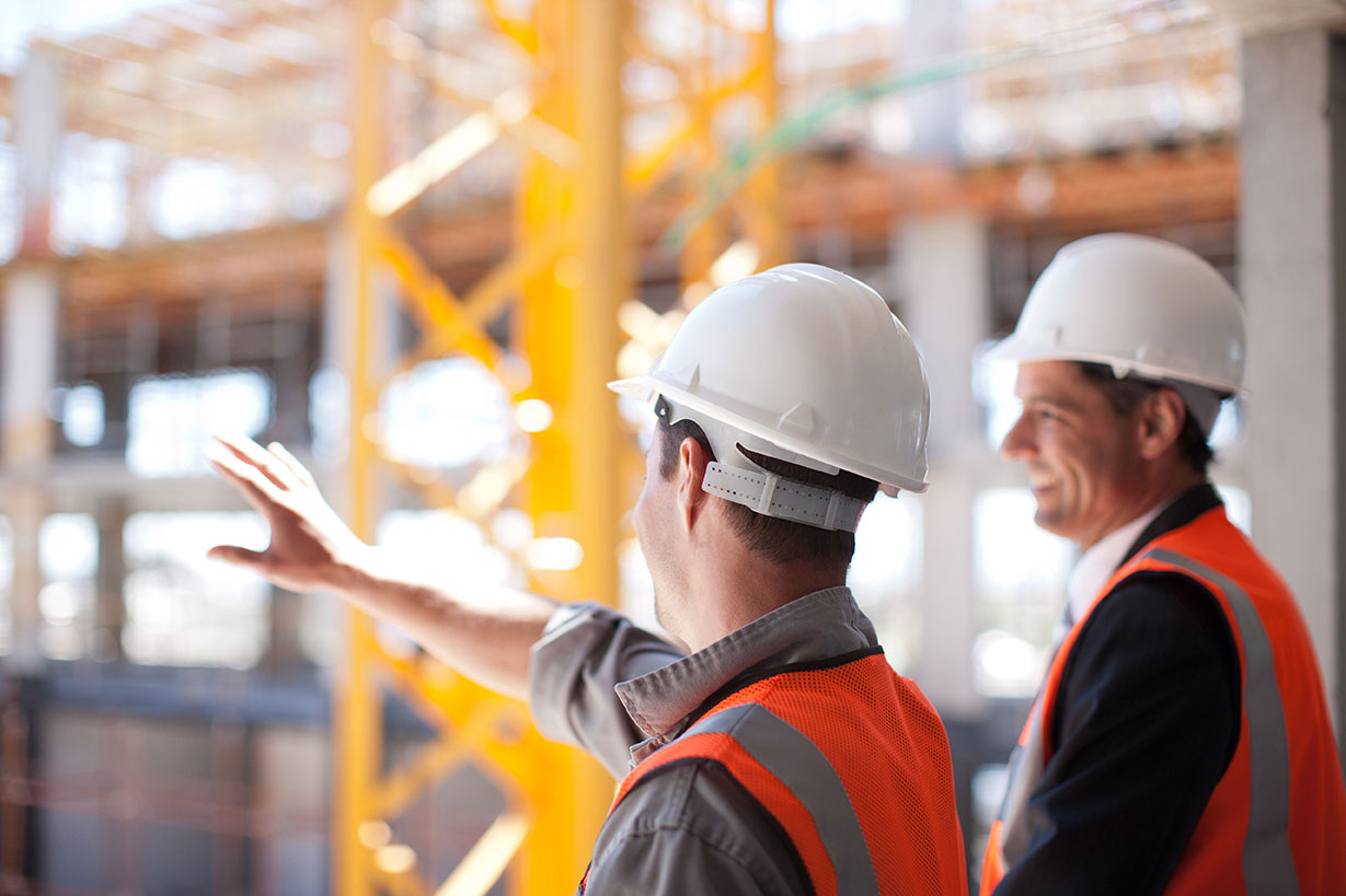 construction workers in hard hats looking out at site