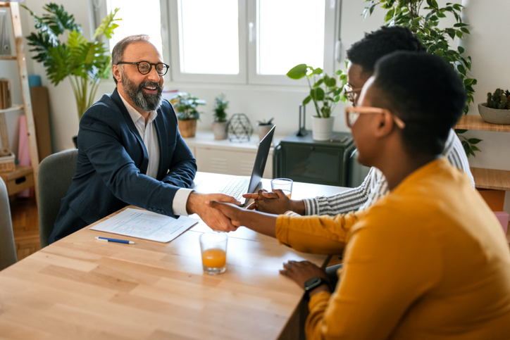 Grateful couple handshake with insurance agent