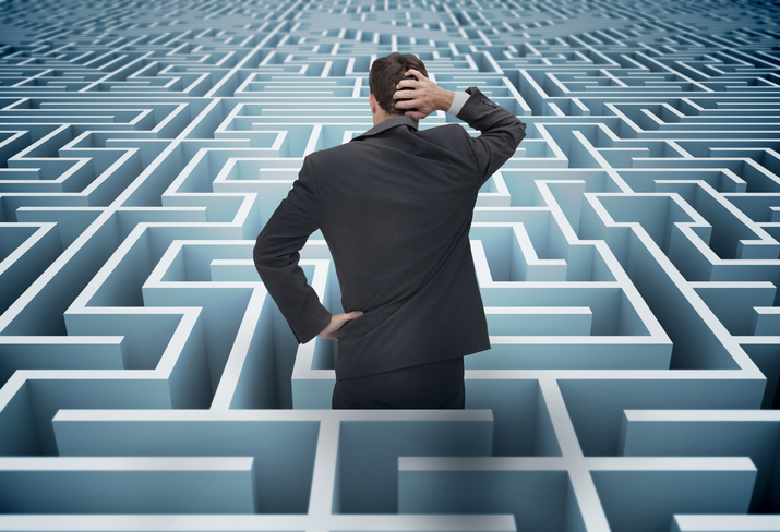businessman in maze scratching his head