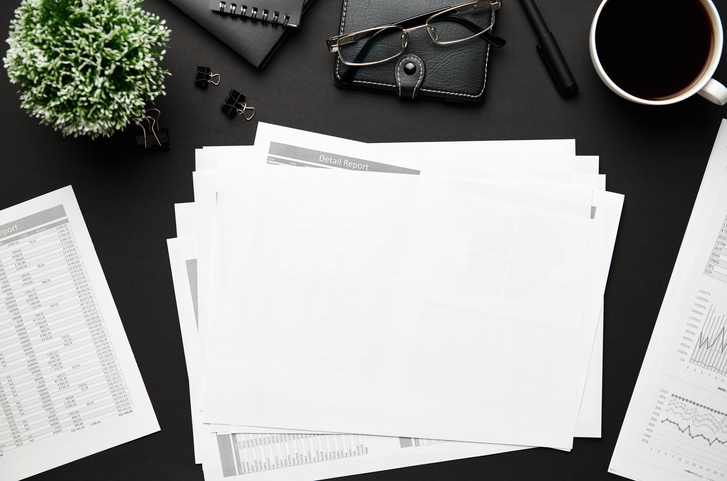 desk with papers and reports scattered all over