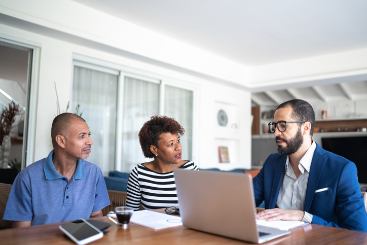 Insurance Agent meeting with couple looking at laptop