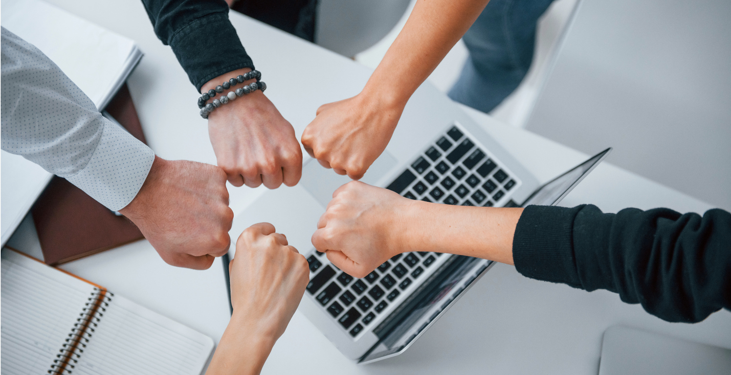 Two independent insurance agents fist bumping after joining an agency network.