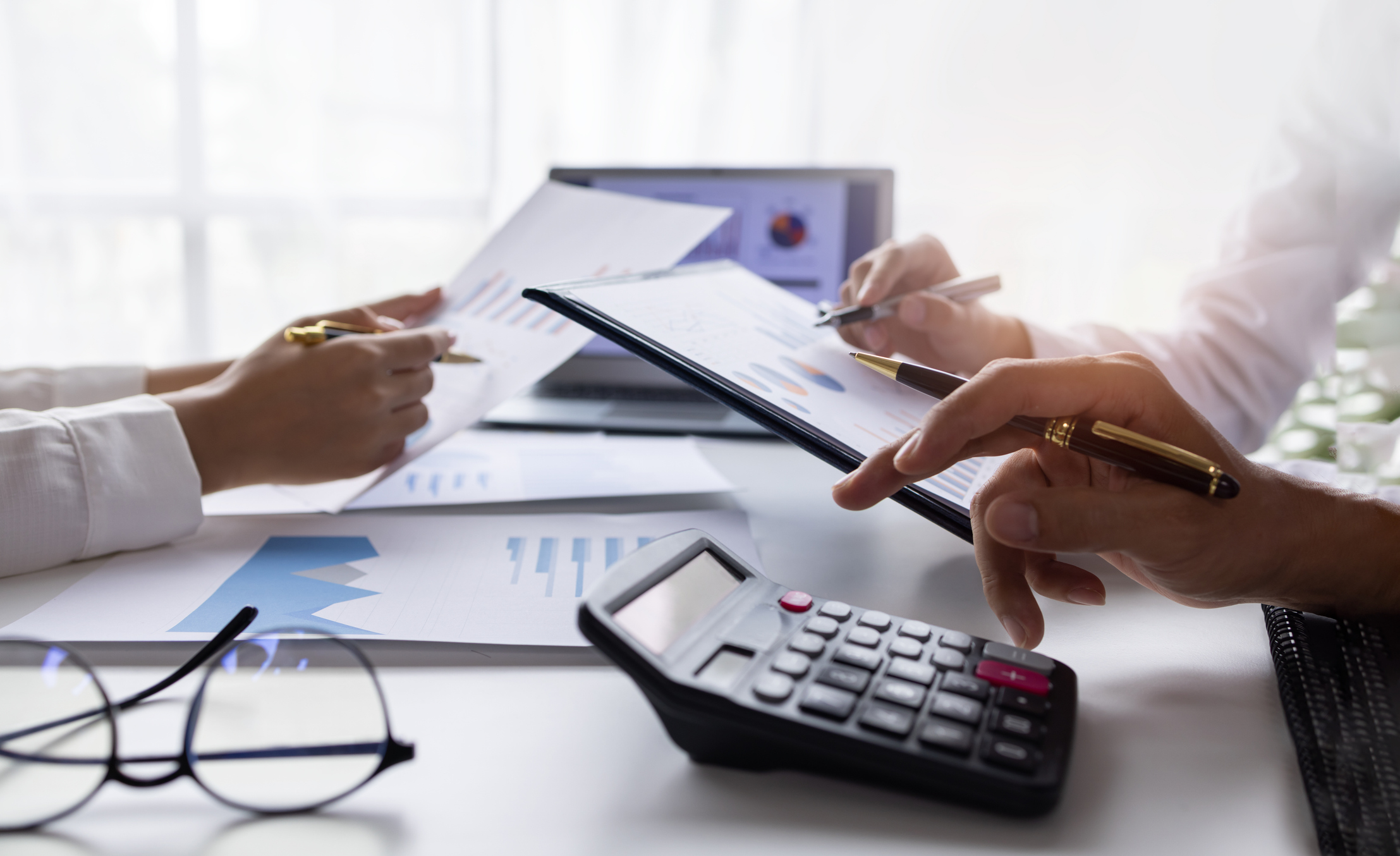Business owner reviewing financial statements and tax documents to prepare their insurance agency for sale.