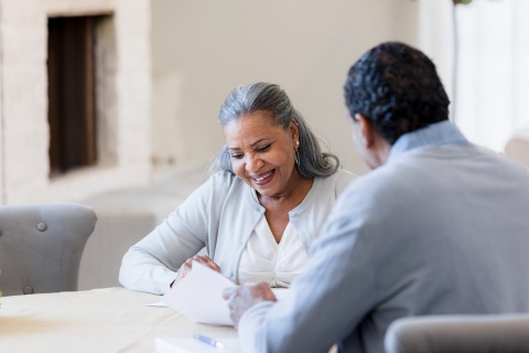 A man and a woman look happy as they review a document