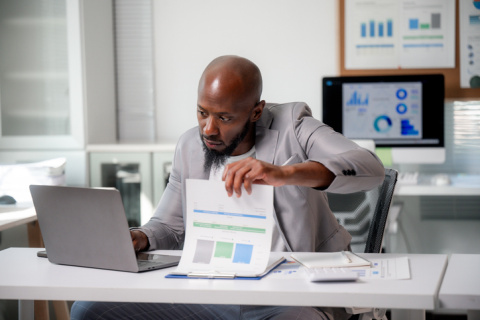 Businessman reviewing profit charts on laptop