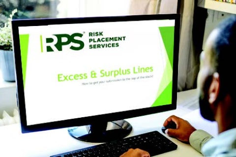 Man on computer Navigating E&S Markets Amid Hard Market Challenges
