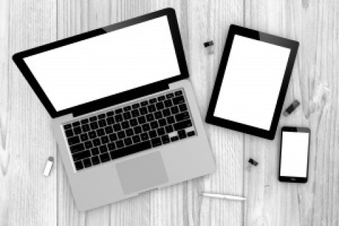 Photo of a computer, a tablet, and a phone