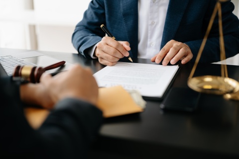 Two lawyers are discussing about contract paper, law matters determination, pointing.law and hammer on the table stock photo