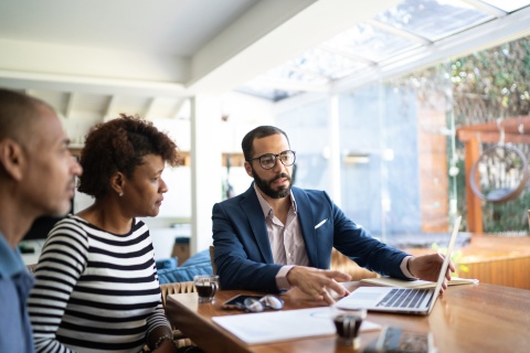 Young, male captive insurance agent meeting with his clients to review policies and quotes.