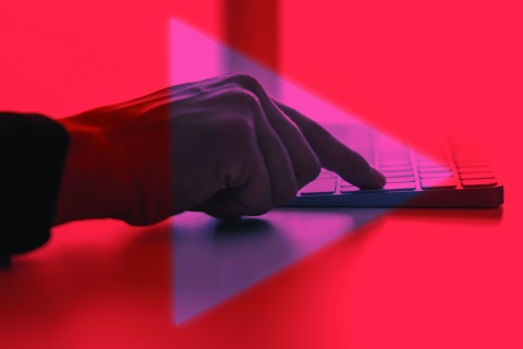 Finger on Keyboard with "Play Button" Symbol