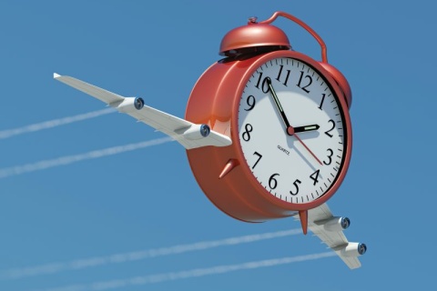 clock with airplane wings flying through the sky
