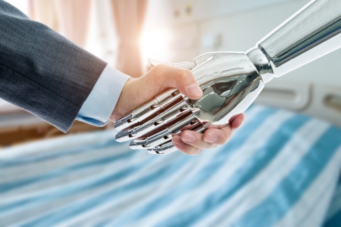 Business insurance man and robot shaking hands, representing technology in insurance underwriters work to determine coverage.