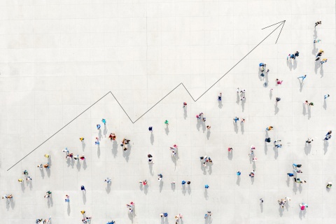 A crowd viewed from above forming a growth graph, symbolizing how marketing agencies use data analytics for client reporting, creating reports, and customer segmentation to unlock growth.