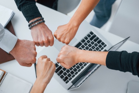 Two independent insurance agents fist bumping after joining an agency network.