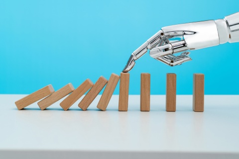 A robotic arm halting a line of falling dominos, symbolizing the insurance business adapting to innovation and the future of insurance. Insurers agree technology is key to preventing risks and ensuring stability.