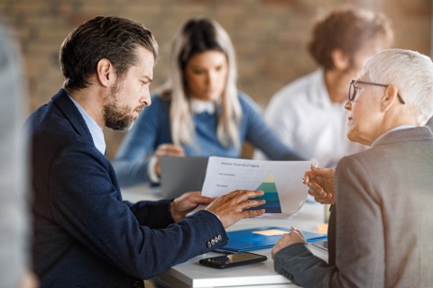 A collaborative team discussing Insurance Industry Trends for customer acquisition costs, integrating machine learning, and optimizing operating models.