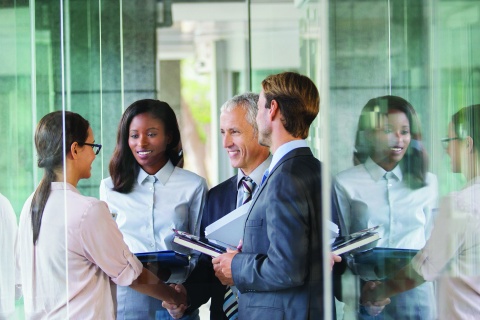 Corporate collaboration in a glass hallway