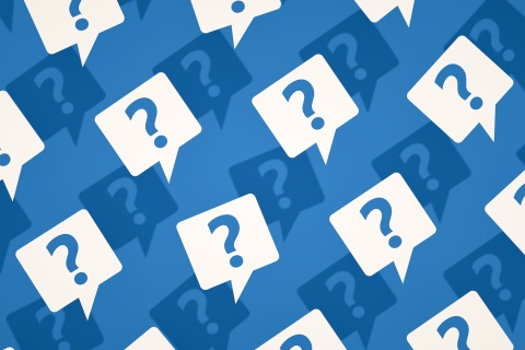 White and navy blue speech bubbles with question marks inside of them on a blue background.