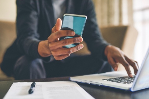 An independent insurance agent preparing to call their Smart Choice territory manager on a mobile phone to ask for advice.