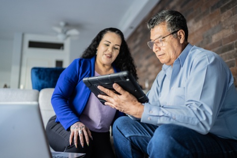 A man and a woman looking at an ipad together, working